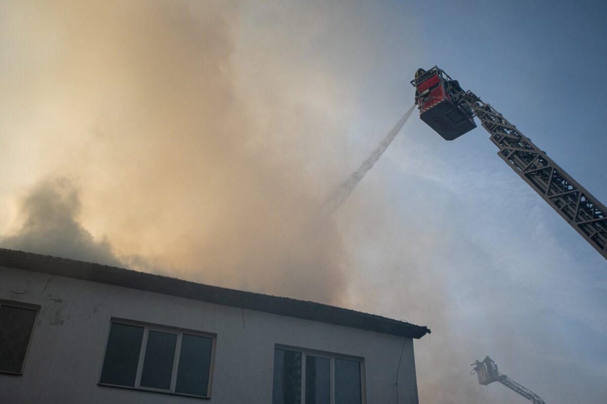 Firefighters using aerial equipment to battle a massive fire