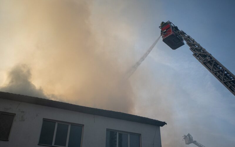 Firefighters using aerial equipment to battle a massive fire