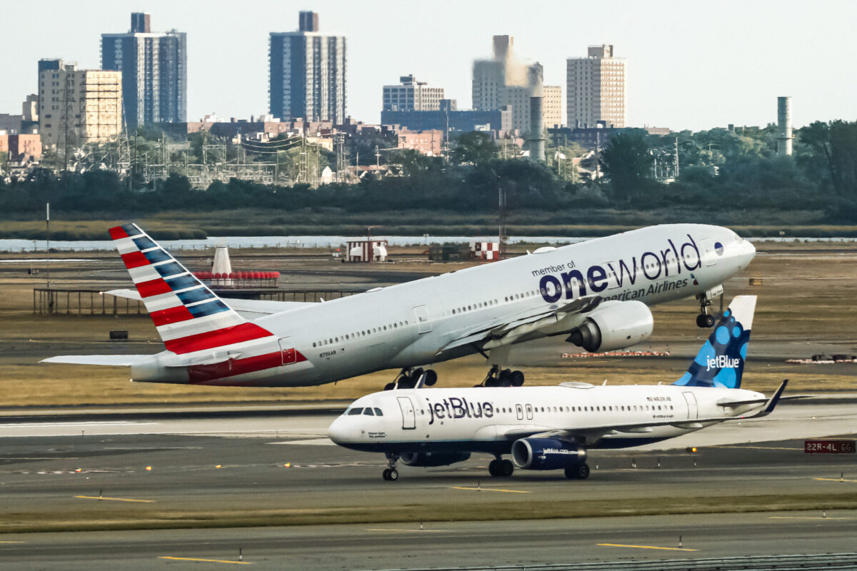 American Airlines Boeing 777 taking off from John F Kennedy International Airport with the jetBlue Airbus A320 taxing behind it