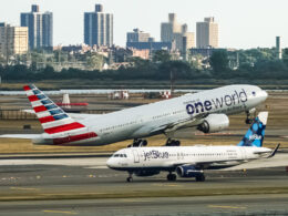 American Airlines Boeing 777 taking off from John F Kennedy International Airport with the jetBlue Airbus A320 taxing behind it