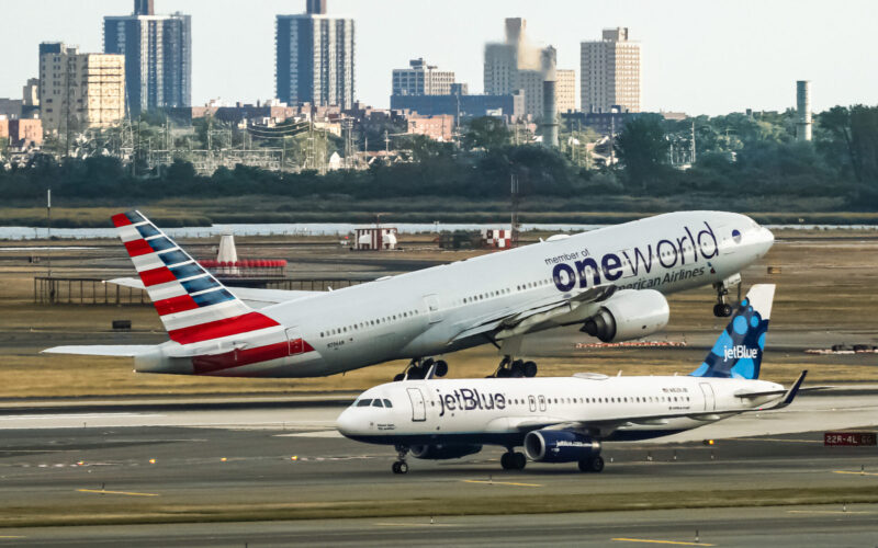 American Airlines Boeing 777 taking off from John F Kennedy International Airport with the jetBlue Airbus A320 taxing behind it