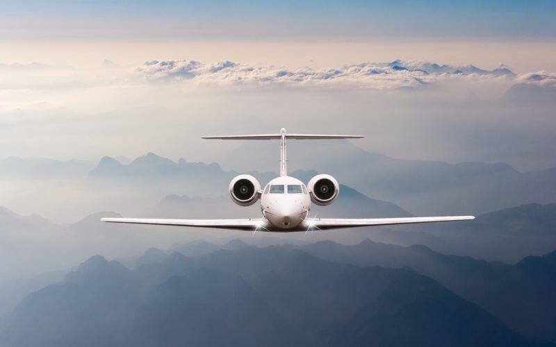 Airplane fly over clouds and Alps mountain on sunset Front view of a big passenger or cargo aircraft business jet airline