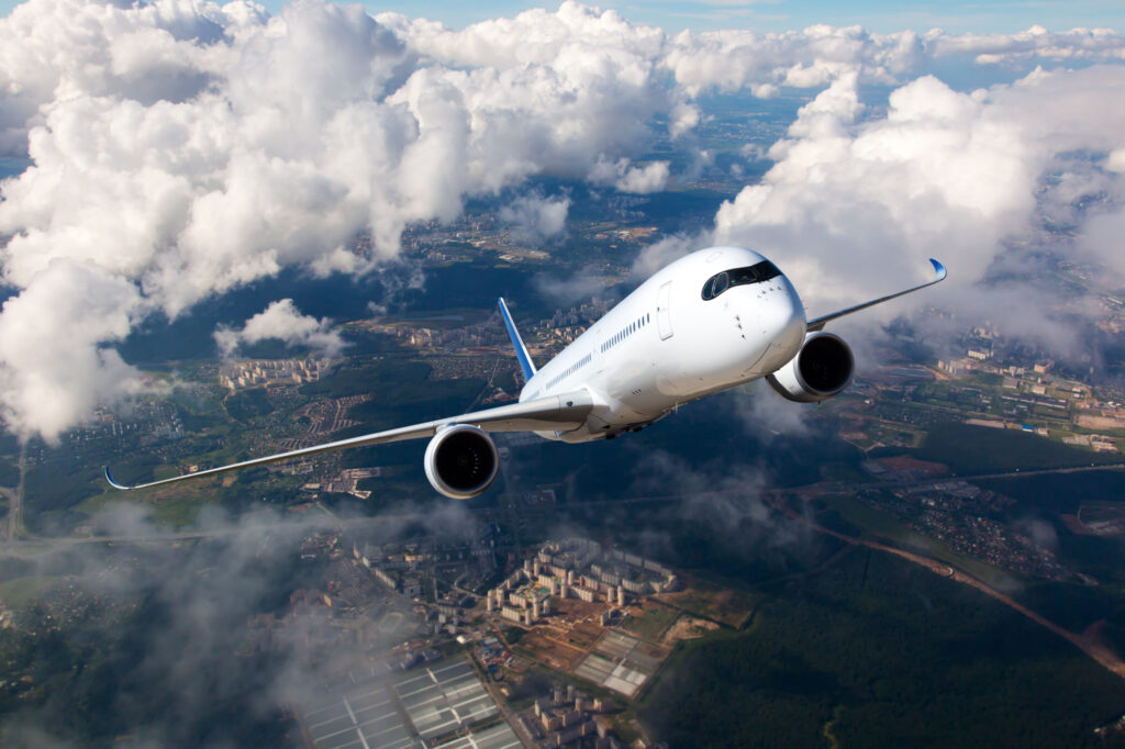 White passenger plane climbs through the clouds Aircraft is flying high above the city