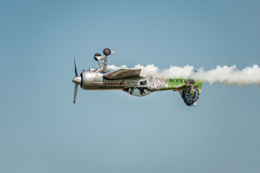 Airshow Wings over Baltics Airshow 2019 Airplane performing at airshow and leaves behind a smokes in the sky Upside down flight