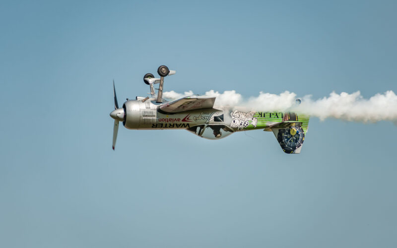 Airshow Wings over Baltics Airshow 2019 Airplane performing at airshow and leaves behind a smokes in the sky Upside down flight