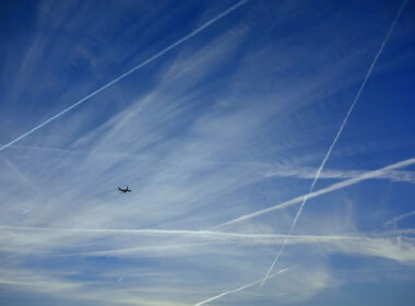 a_plane_flying_with_contrails.jpg