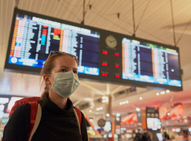 a_woman_with_a_mask_on_at_an_airport_covid-19.jpg