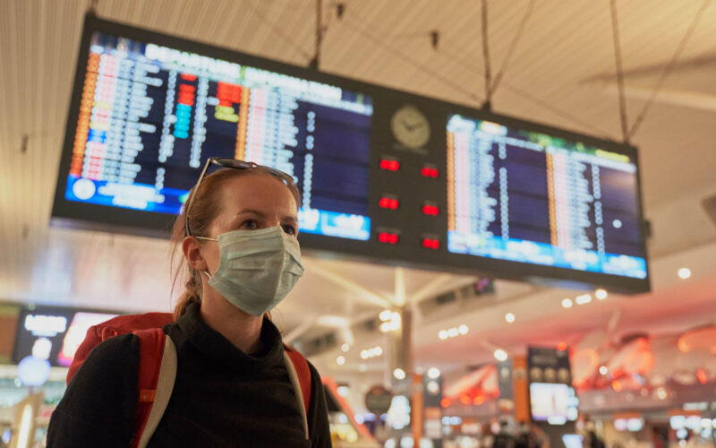 a_woman_with_a_mask_on_at_an_airport_covid-19.jpg