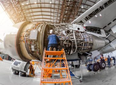 Specialist mechanic repairs the maintenance of a large engine of a passenger aircraft in a hangar