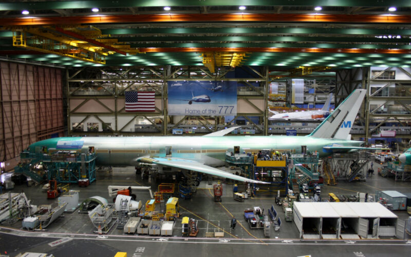 Unidentified Boeing employees continue work building a Boeing 777 jets at its Everett factory including for KLM Royal Dutch Airlines with a Boeing 787 behind