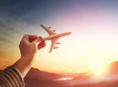 child_holds_a_toy_plane_in_the_sky.jpg