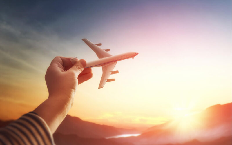 child_holds_a_toy_plane_in_the_sky.jpg