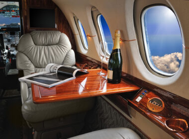 luxury interior in the modern business jet and sunlight at the window/sky and clouds through the porthole