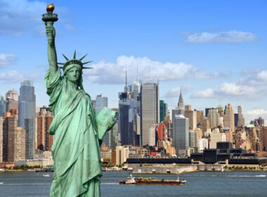 new york city skyline cityscape with statue of liberty over hudson river. with midtown Manhattan skyscrapers and freight sailing ship in usa america.